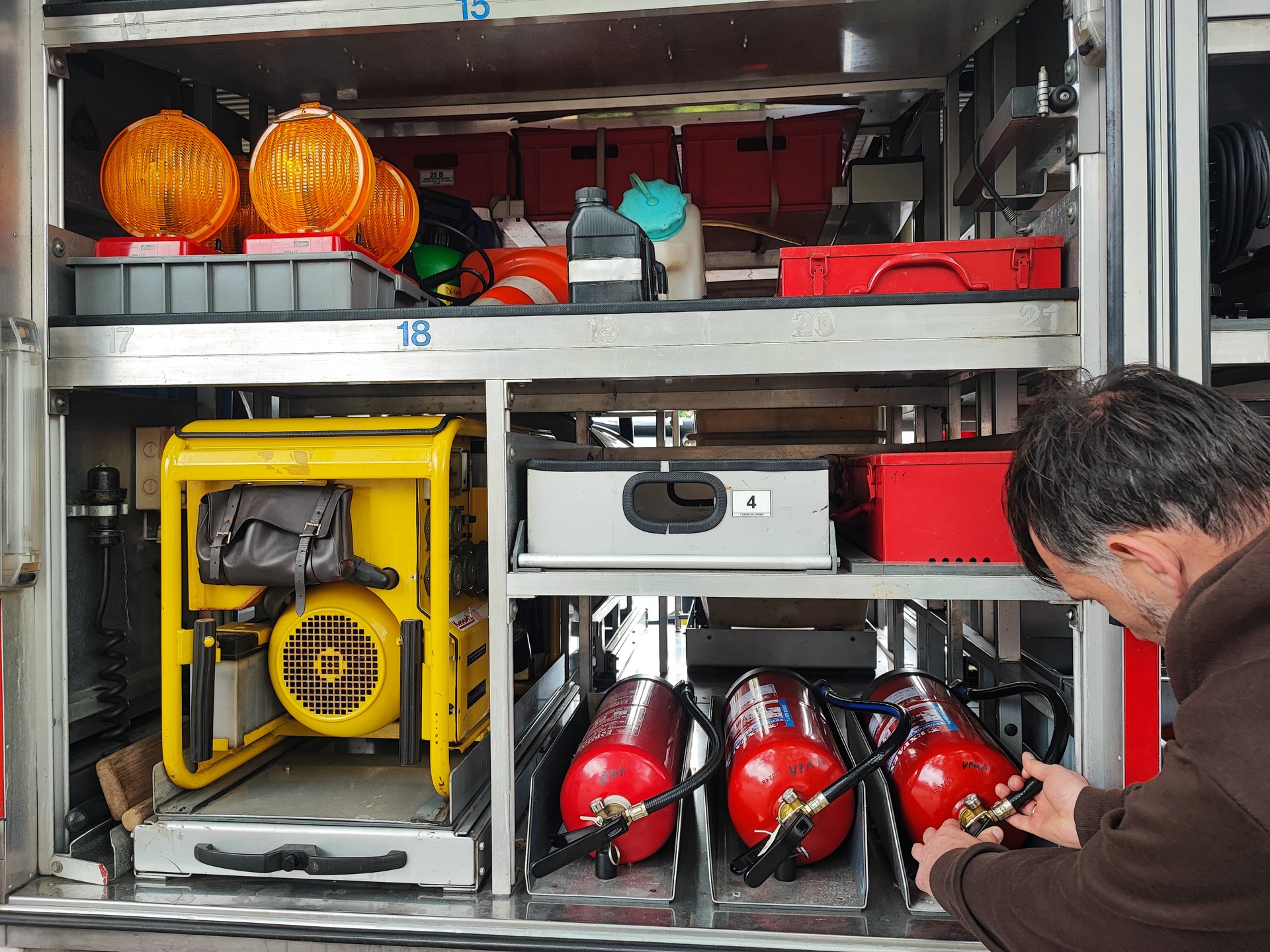 Close-up of a man's hand with fire equipment in a fire truck. Man turns control levers